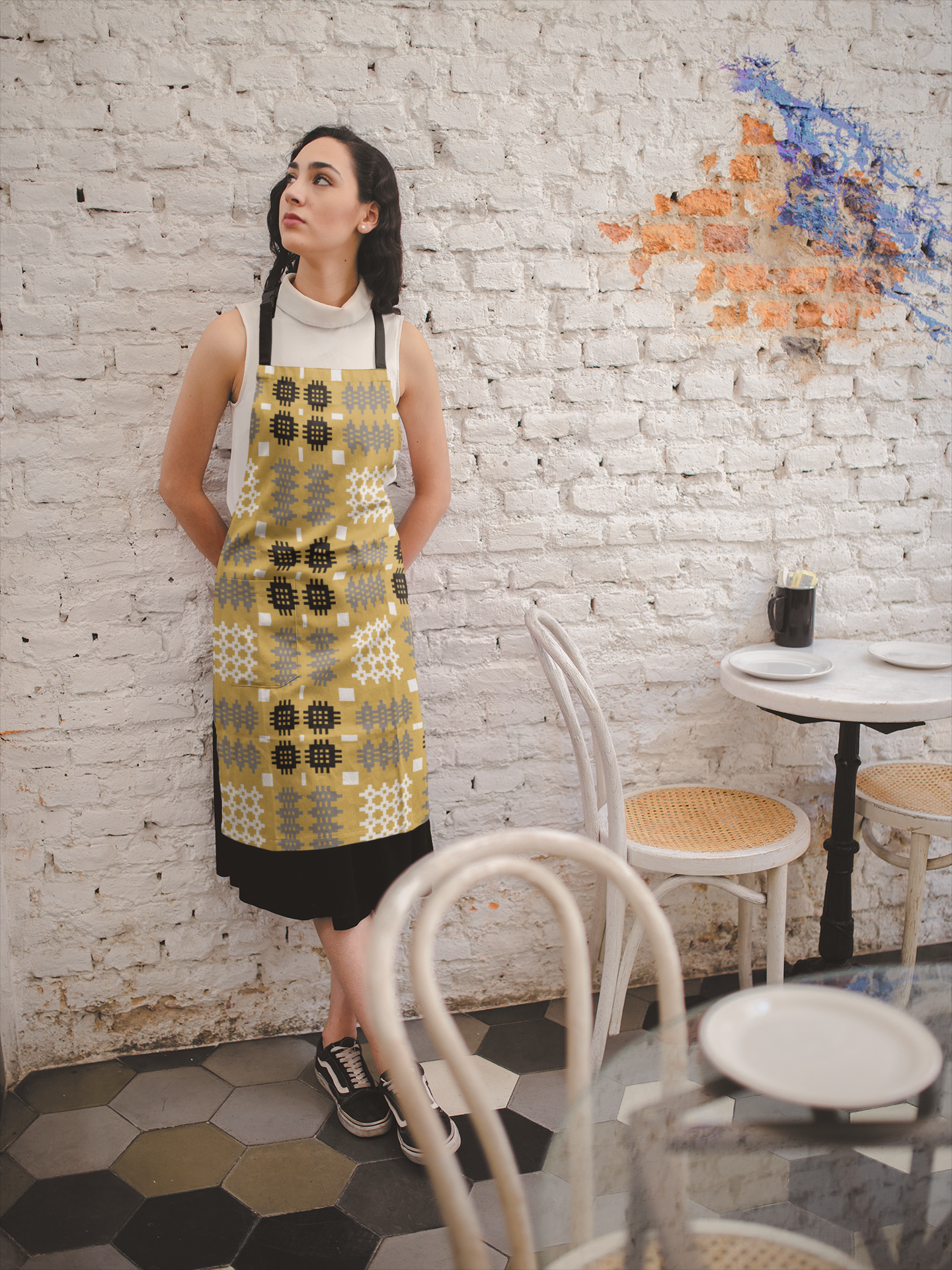girl-wearing-a-welsh-tapestry-print-apron-against-a-white-bricks-wall