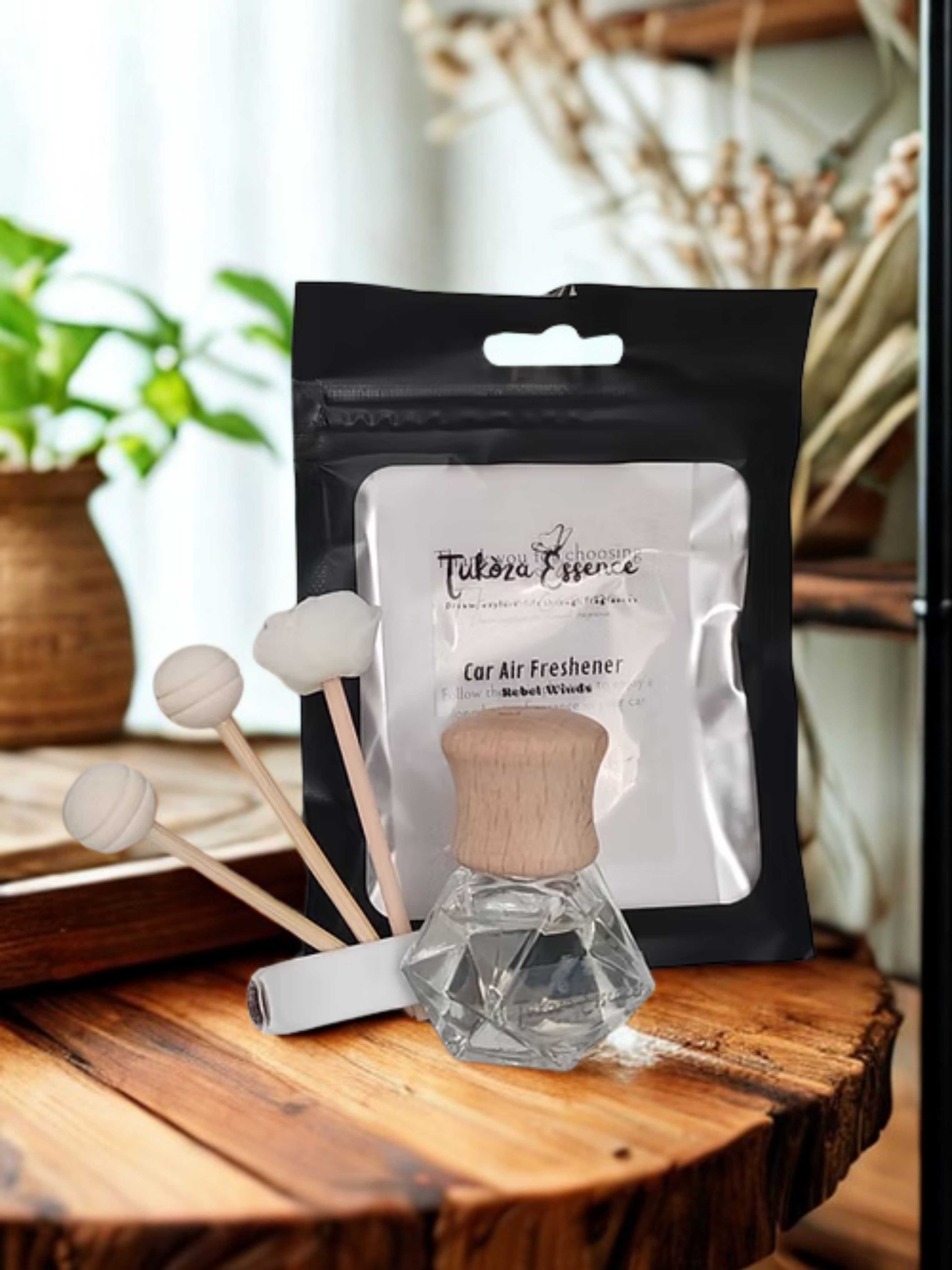 Rebel Winds Car Air Freshener – Rustic Display with Reeds Rebel Winds car air freshener displayed on a rustic wooden table with three diffuser reeds – natural and elegant presentation